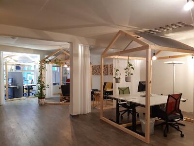Der Innenraum der Co-Community in Zofingen (4800, Kanton Aargau) zeigt moderne Arbeitsplätze mit Tischen, Sitzbereichen und Pflanzen in einer hellen Umgebung.