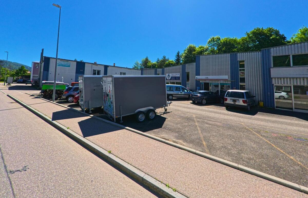 In Cortébert (2607, Kanton Bern) befindet sich ein kleines Gewerbeareal mit mehreren Firmengebäuden und Parkplätzen entlang einer Seitenstrasse.