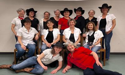 In Ebnat-Kappel (9642, Kanton St. Gallen) posiert eine Gruppe von Country-Tänzerinnen in Westernkleidung und Cowboyhüten für ein gemeinsames Foto.
