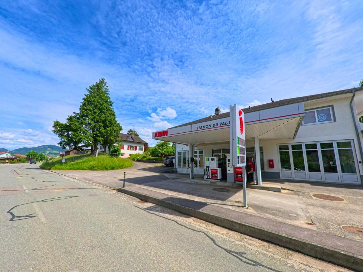 Die Tankstelle Jubin an der Hauptstrasse von Courchapoix (2825, Kanton Jura) liegt zwischen Wohnhäusern und bietet zwei Zapfsäulen unter einem Vordach.