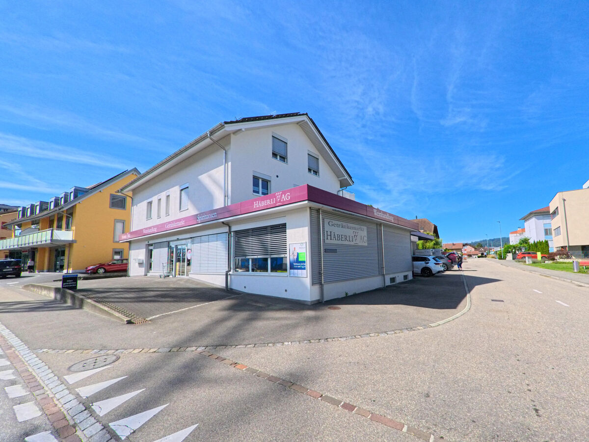  In Dagmersellen (6252, Kanton Luzern) liegt an einer Strassenecke das Geschaeftshaus der Haberli AG mit geschlossenen Rolllaeden, umgeben von Wohngebaeuden und Parkplaetzen.