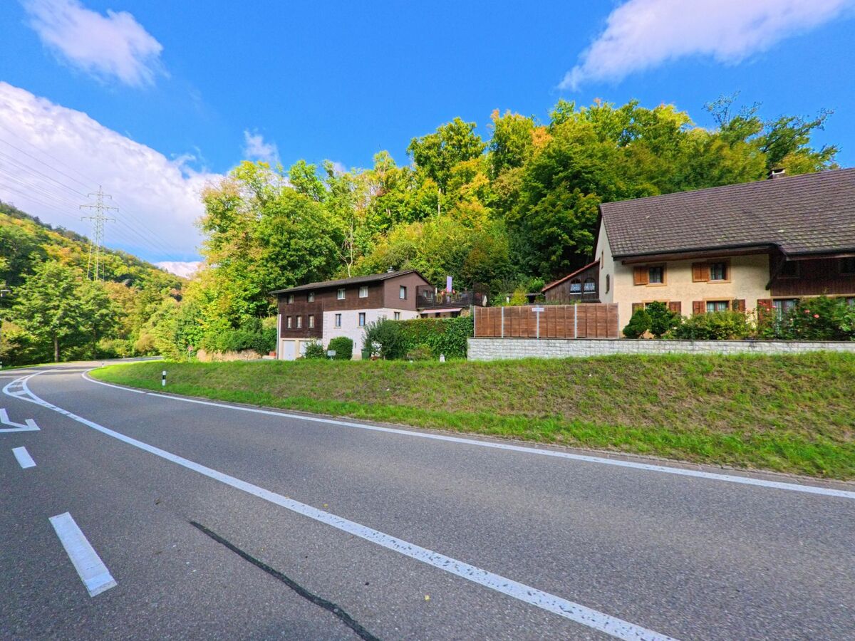 Am Ortsrand von Densbüren (5026, Kanton Aargau) liegen Einfamilienhäuser mit gepflegten Gärten entlang einer sanft geschwungenen Landstrasse.