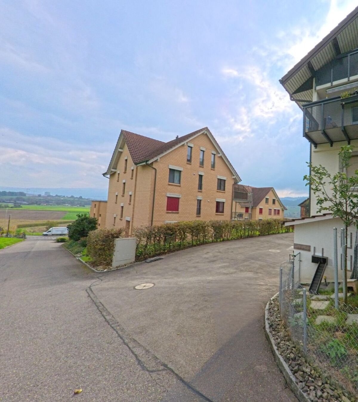 Am Siedlungsrand von Dietwil (6042, Kanton Aargau) stehen moderne Mehrfamilienhäuser mit Blick über die Felder und das Reusstal.