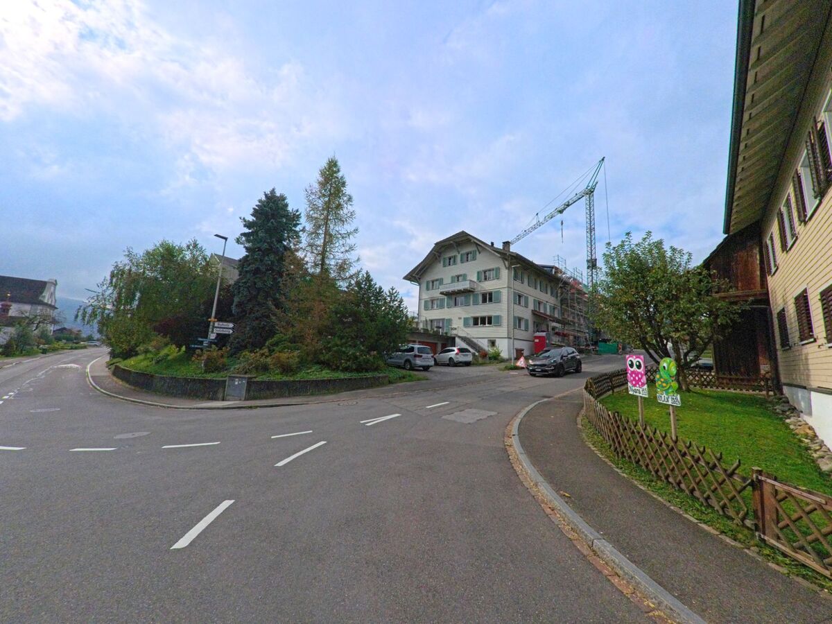 Im Zentrum von Dietwil (6042, Kanton Aargau) treffen sich mehrere Strassen an einer Kurve mit Wohnhäusern, Gärten und einem im Bau befindlichen Gebäude.