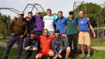 In Adliswil (8134, Kanton Zuerich) steht eine Gruppe von Spielern des Disc Golf Club Big Birdies Adliswil gut gelaunt im Freien zusammen und posiert mit einer Wurfscheibe fuer ein Mannschaftsfoto.