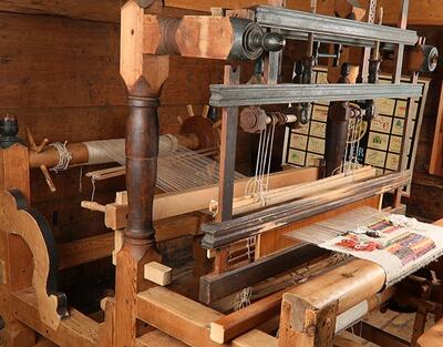 Im Dorfmuseum Wiesen in Davos Wiesen (7494, Kanton Graubünden) steht ein historischer Webstuhl aus Holz, der traditionelle Handwerkskunst und alte Webtechniken zeigt.