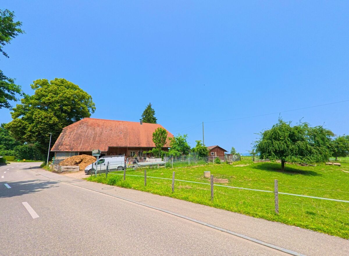 Ein traditioneller Bauernhof mit rotem Ziegeldach liegt in Drei Höfe (4558, Kanton Solothurn) am Rand einer Strasse, umgeben von Wiese und Wirtschaftsgebäuden.