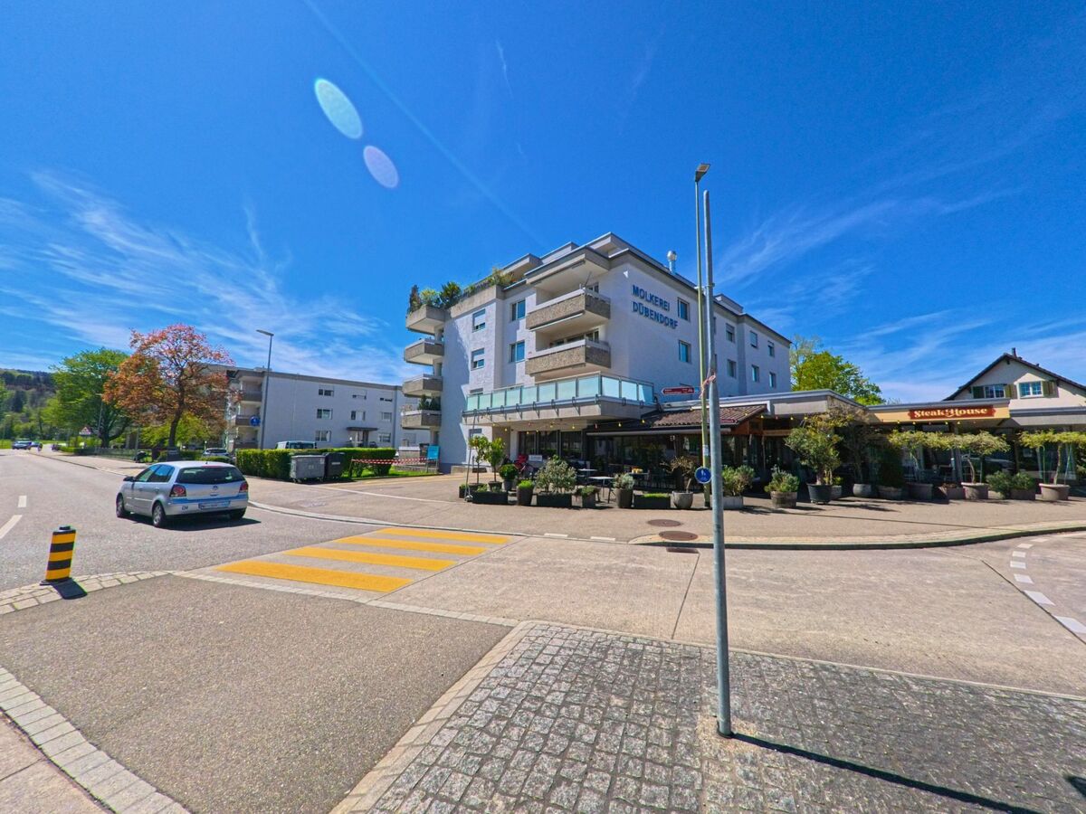 In [ORT], PLZ [PLZ], im [KANTON] befindet sich an einer gut befahrenen Strasse das Gebäude „Molkerei Dübendorf“ mit einem Restaurant im Erdgeschoss.