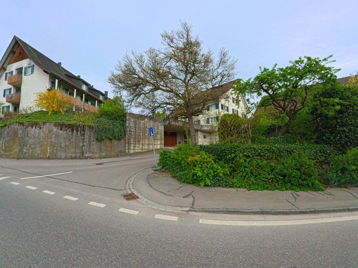 Ein steiler Strassenabschnitt mit teils begrünten Mauern und Wohnhäusern prägt das Ortsbild von Ellikon an der Thur, PLZ 8548 im Kanton Zürich.