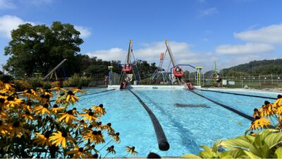 Am Erlebnisflugplatz Sitterdorf in Sitterdorf (8589, Kanton Thurgau) befindet sich ein Freizeitbereich mit Wasserbecken und Spielgeraeten vor gruener Landschaft.