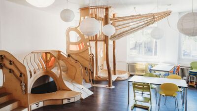Im Familienzentrum Karussell Region Baden (5400, Kanton Aargau) lädt ein heller Raum mit fantasievoller Holzspielstruktur und bunten Stühlen zum Spielen und Verweilen ein.
