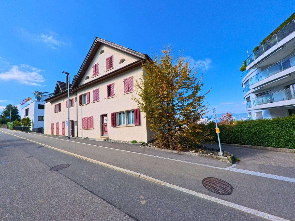 Ein älteres Wohnhaus mit farbigen Fensterläden prägt einen Strassenabschnitt in Feusisberg (8835, Kanton Schwyz).