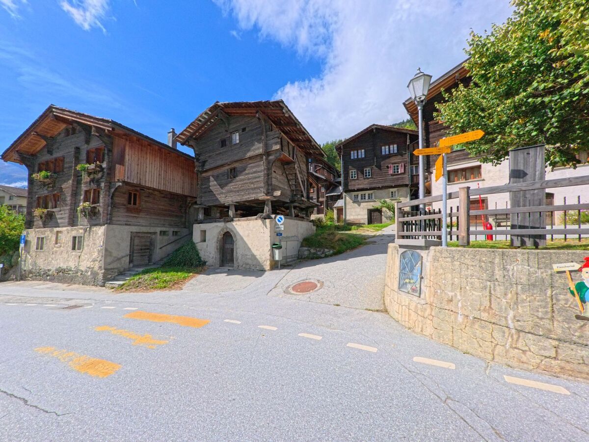 Alte Holzhäuser auf steinernen Fundamenten bilden ein malerisches Strasseneck im historischen Zentrum von Fiesch (3984, Kanton Wallis).