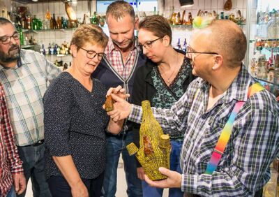 In Willisau (6130, Kanton Luzern) betrachten mehrere Personen im Museum gemeinsam kunstvoll geformte Glasflaschen und diskutieren interessiert darüber.In Willisau (6130, Kanton Luzern) betrachten mehrere Personen im Museum gemeinsam kunstvoll geformte Glasflaschen und diskutieren interessiert darüber.