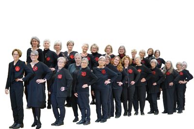 Vor hellem Hintergrund steht in Altstätten (9450, Kanton St. Gallen) der Frauenchor geschlossen in schwarzer Kleidung mit roten Akzenten zu einem formellen Gruppenfoto