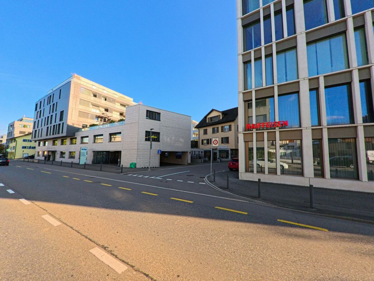 Zwischen modernen Fassaden und kleineren Wohnhaeusern liegt in Freienbach (8808, Kanton Schwyz) eine ruhige Strasse, vor der das Raiffeisen-Gebaeude praegnant hervorsticht.