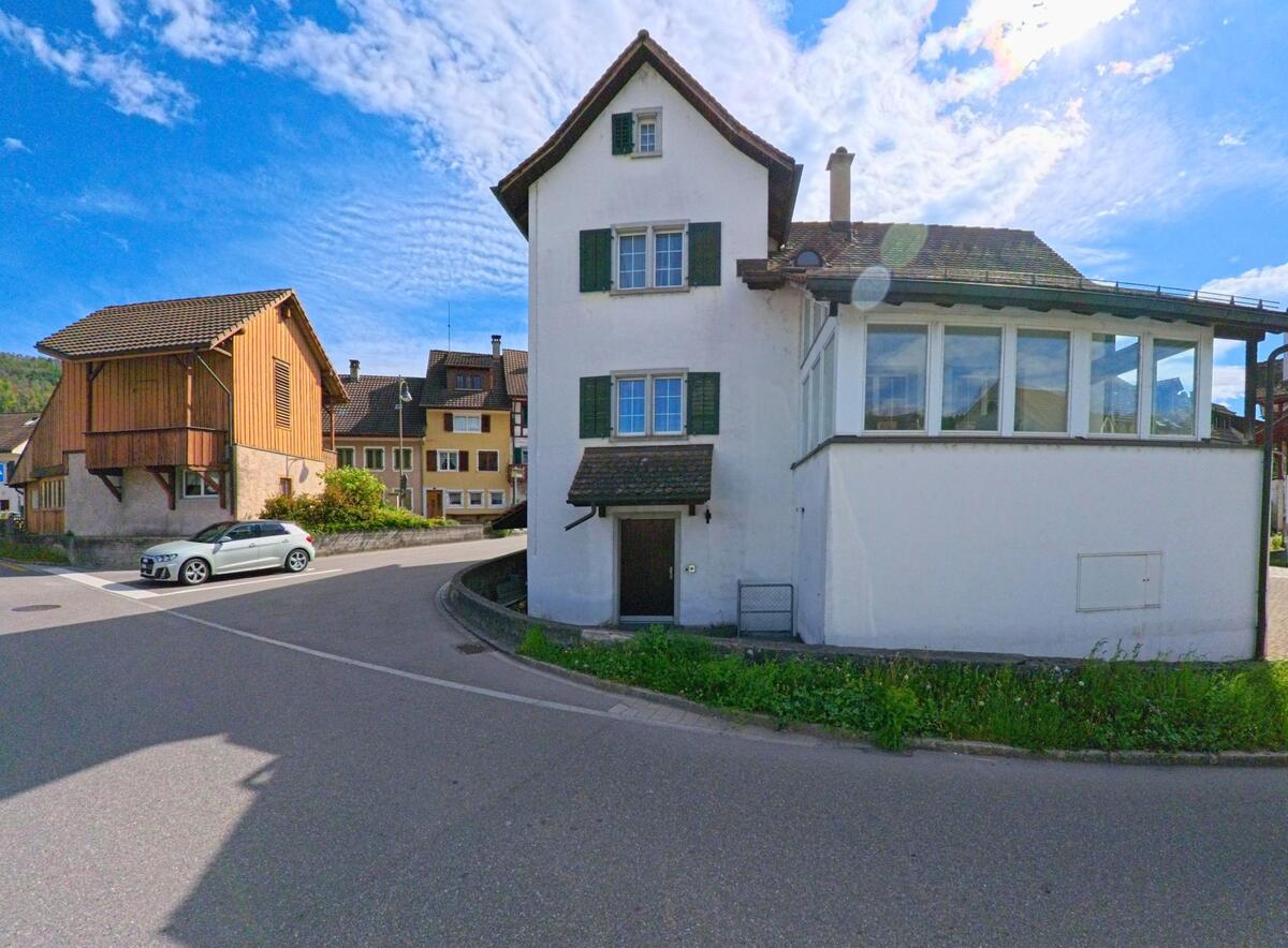 Im alten Dorfkern von Freienstein-Teufen (PLZ 8427, Kanton Zürich) stehen dicht aneinander gereihte Wohnhäuser mit traditionellen Fassaden an einer engen Strassenbiegung.