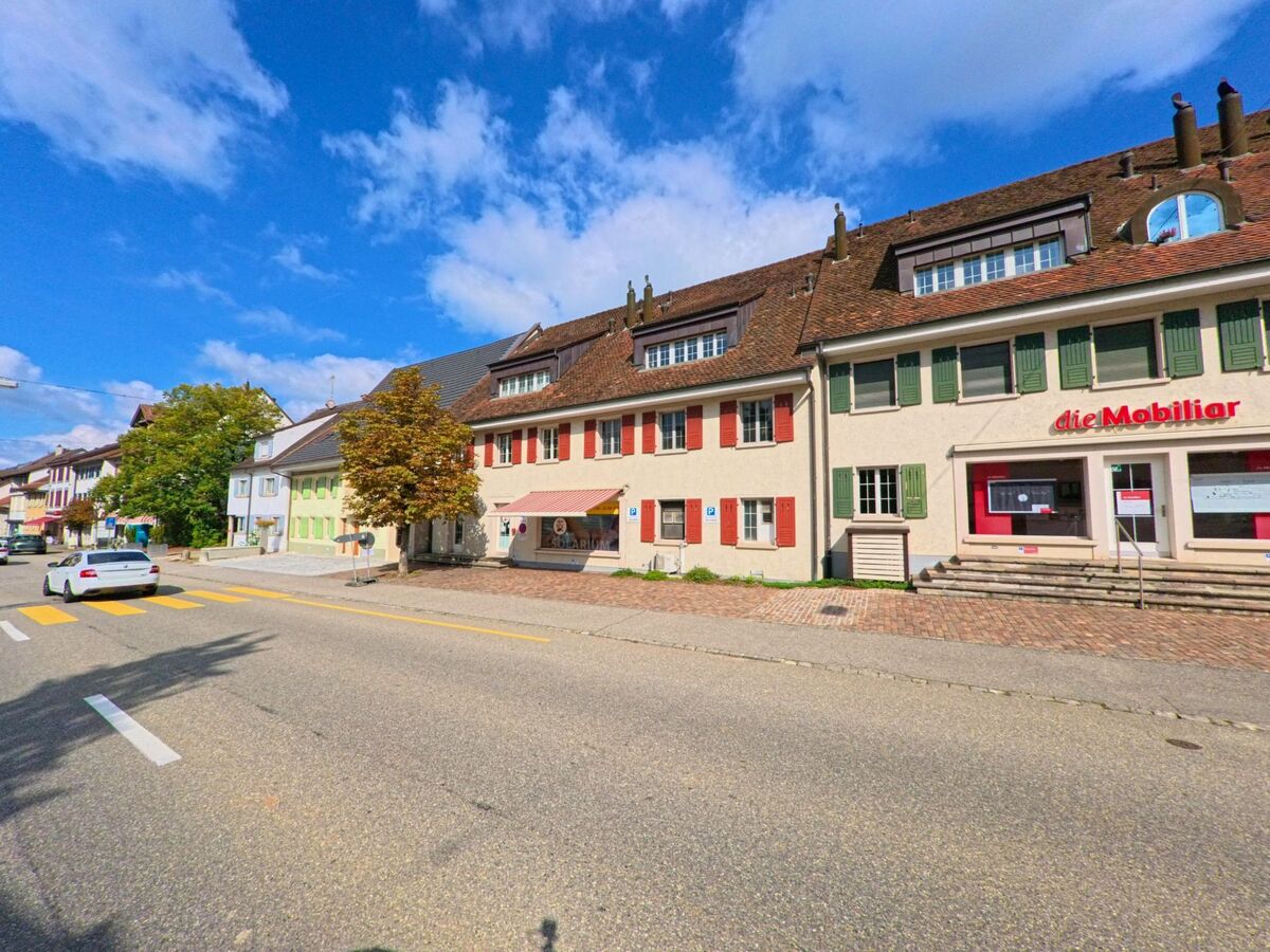 Entlang der Hauptstrasse in Frick (5070, Kanton Aargau) stehen traditionelle Wohn- und Geschaeftshaeuser mit farbigen Fensterlaeden und kleinen Laeden im Erdgeschoss.