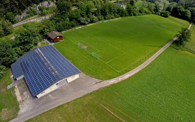 Aus der Vogelperspektive ist in Kleinlützel (4245, Kanton Solothurn) eine gepflegte Fussballanlage mit Spielfeld, Vereinsgebaeude und umliegenden Gruenflaechen zu sehen.