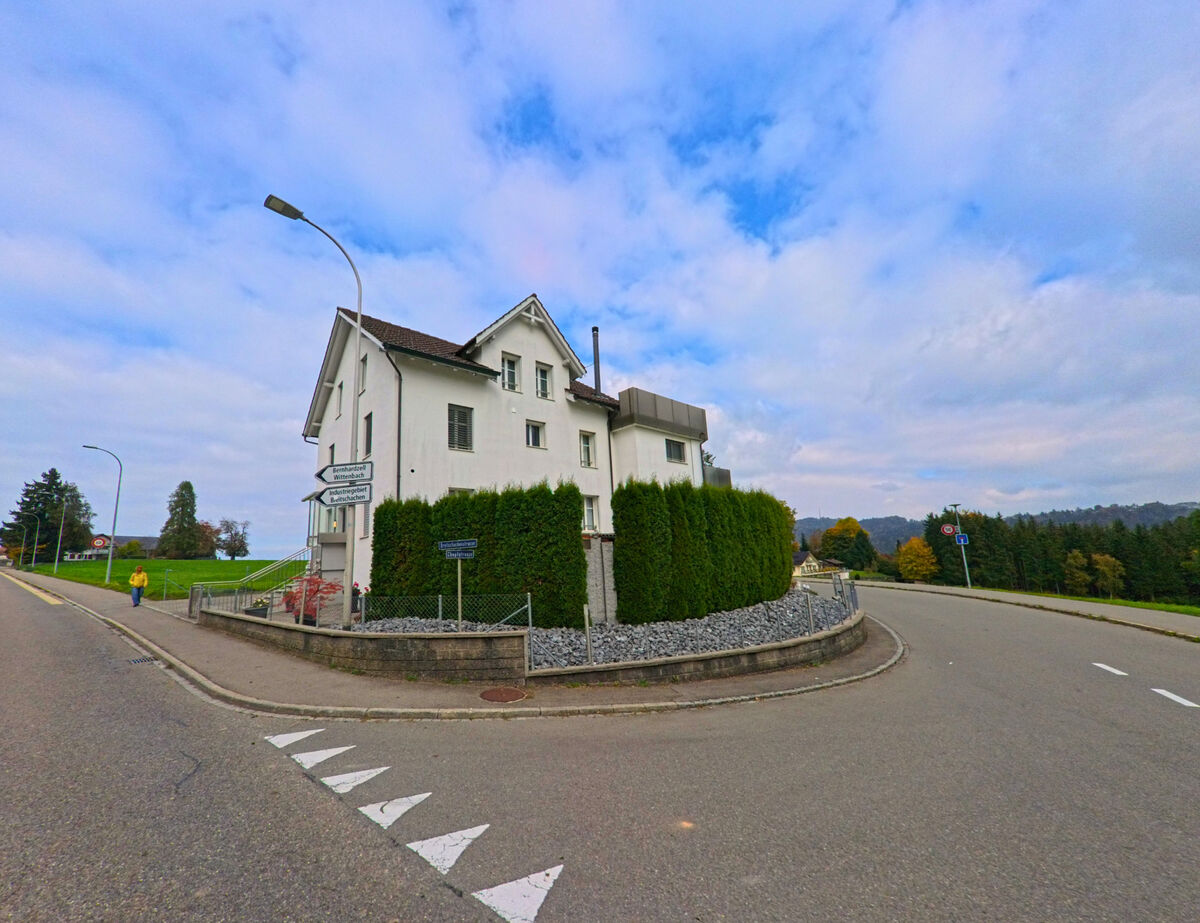 An einer Weggabelung mit Markierungen steht ein Wohnhaus in Gaiserwald (9032, Kanton St. Gallen) leicht erhoeht.