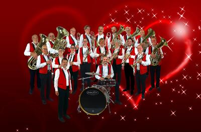 Die Gallus Musikanten stehen in St. Gallen (9000) im Kanton St. Gallen mit Blasinstrumenten vor rotem Hintergrund mit Sternmotiven.