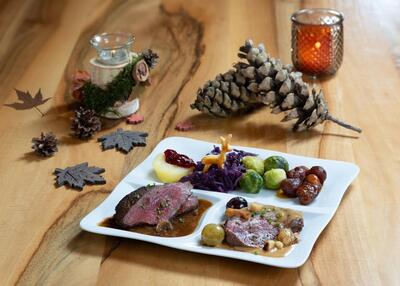Im Gasthaus zum Löwen in Rickenbach (6221, Kanton Luzern) wird ein herbstlich dekoriertes Gericht mit Fleisch, Rotkohl und Gemüse serviert.