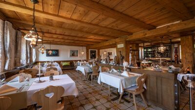 Der Gasthof Bad Schwarzenberg in Gontenschwil (5728, Kanton Aargau) zeigt einen gemütlichen Gastraum mit Holzbalkendecke, eingedeckten Tischen und stimmungsvoller Beleuchtung.