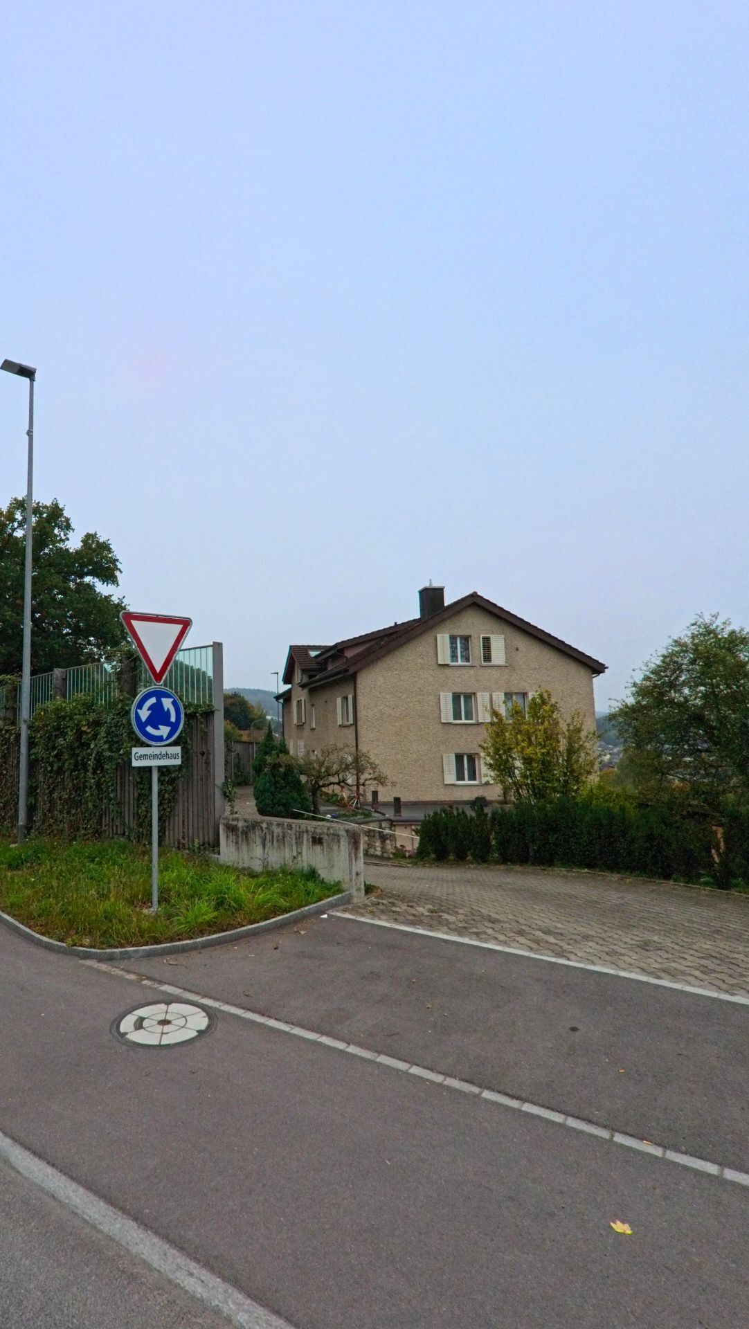 Ein Wegweiser mit der Aufschrift „Gemeindehaus“ steht an einer Strasseneinmündung in Gebenstorf (5412, Kanton Aargau) vor einem mehrstöckigen Wohnhaus.