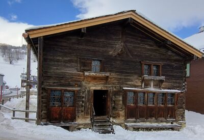 In Wildhaus (9658, Kanton St. Gallen) steht das Geburtshaus von Huldrych Zwingli, ein historisches, aus Holz gebautes Gebäude, umgeben von Schnee und Bergen.