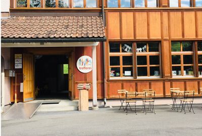 Ein schlichtes Gebaeude mit Eingangsbereich und Vorplatz steht in Wildhaus-Alt St. Johann (9658, Kanton St. Gallen) als Treffpunkt fuer die Bevoelkerung.