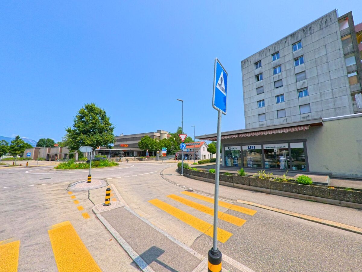 In Gerlafingen (4563, Kanton Solothurn) treffen sich an einem Kreisverkehr mehrere Strassen, flankiert von einem Supermarkt, Wohnhäusern und einem Geschäft für Haushaltwaren.