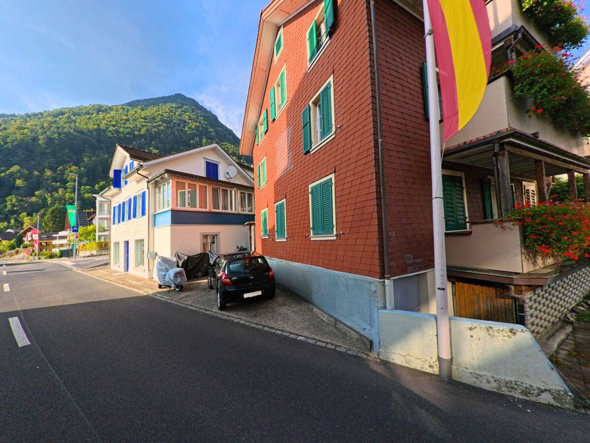 Mehrere Wohnhäuser reihen sich entlang einer schmalen Strasse im Dorfgebiet von Gersau (6442, Kanton Schwyz).