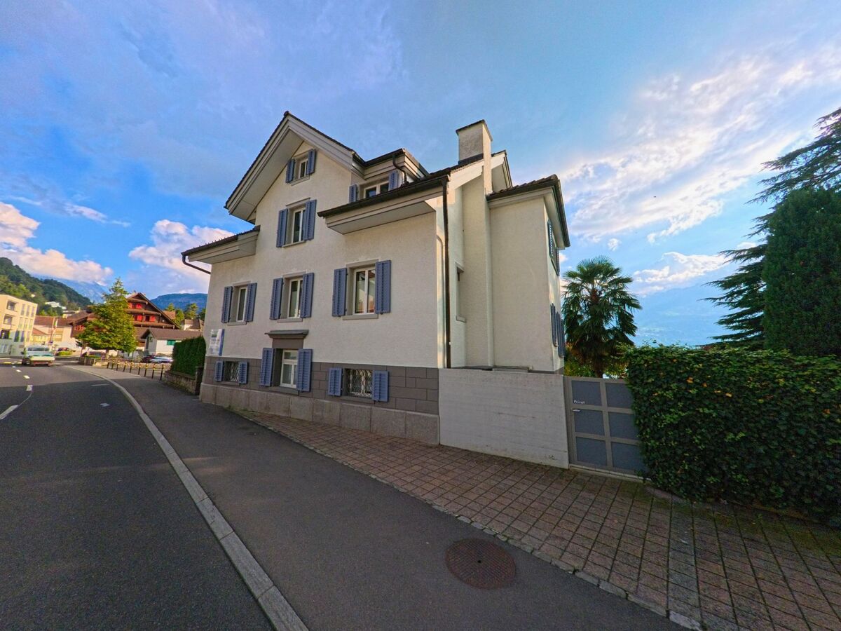 Ein Wohnhaus mit heller Fassade grenzt an den Gehweg in Gersau (6442, Kanton Schwyz).