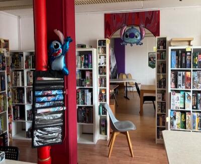 Ein heller Raum mit Regalen voller Brettspiele und Spielflaechen ist als Treffpunkt in Oberwil (4104, Kanton Baselland) eingerichtet.
