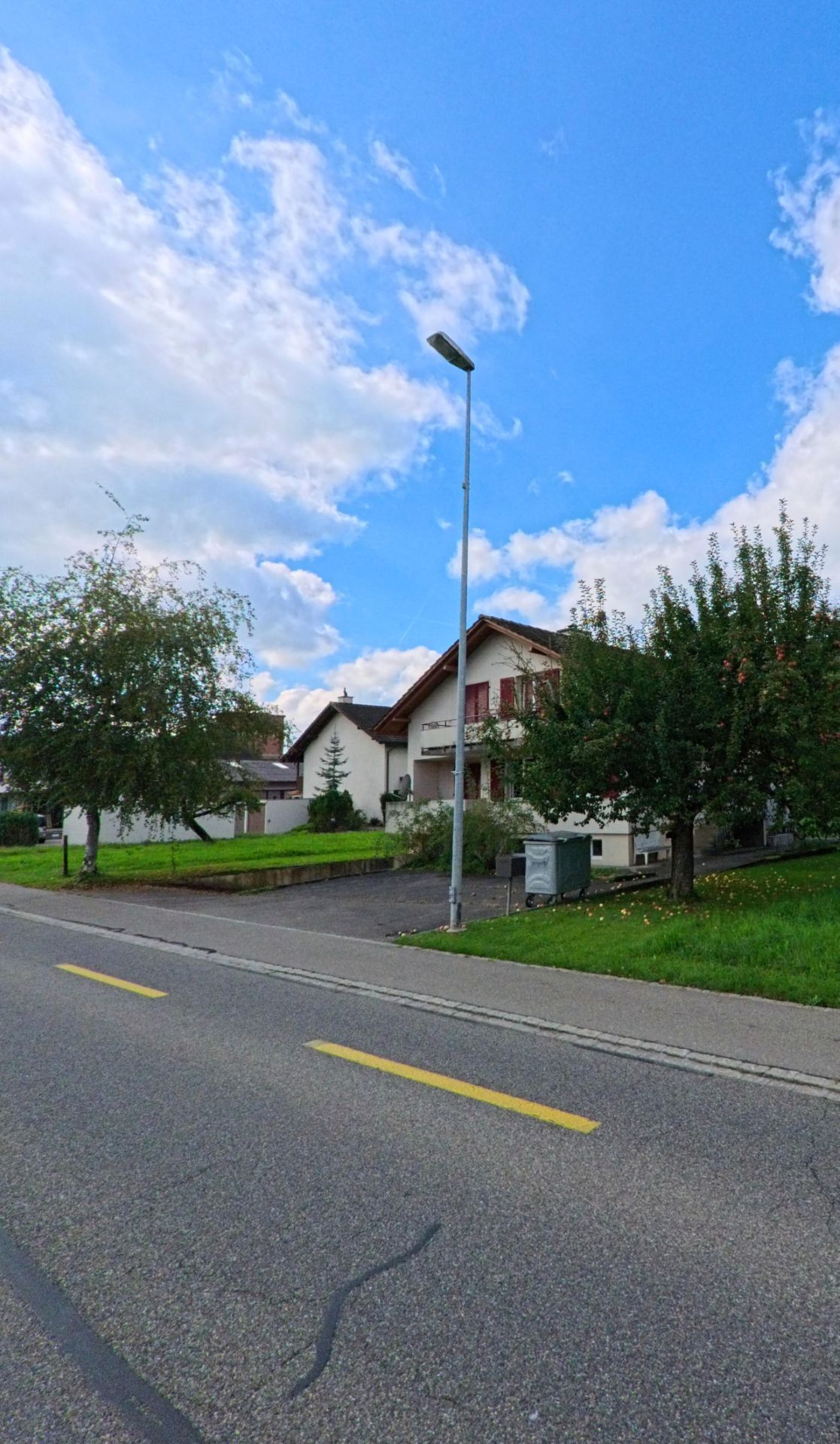 Ein Einfamilienhaus mit rotem Dach und Garten liegt an einer Wohnstrasse in Gipf-Oberfrick (5073, Kanton Aargau), umgeben von Baeumen und gepflegten Gruenflaechen.