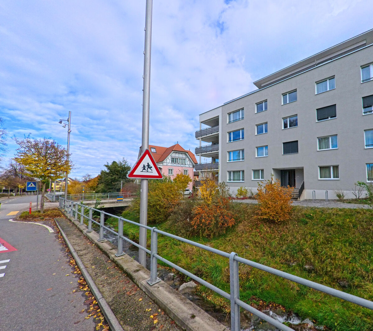 Ein schmaler Weg verlaeuft neben einem Bach und Wohngebaeuden in Goldach (9403, Kanton St. Gallen).