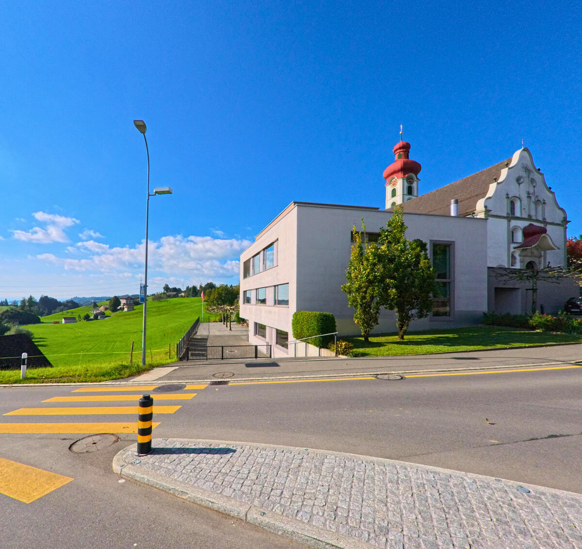 Die Kirche steht nahe einer Strassenkreuzung in Gommiswald (8737, Kanton St. Gallen) mit freiem Blick auf das Umfeld.