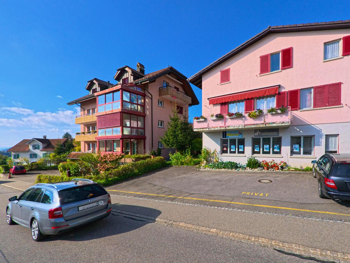 Farbige Wohnhaeuser mit Balkonen praegen das Quartierbild in Gommiswald (8737, Kanton St. Gallen).