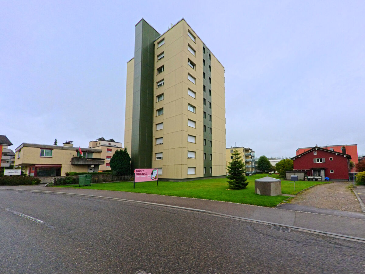 Ein markantes Hochhaus steht frei auf einer Gruenflaeche in Gossau (9200, Kanton St. Gallen).