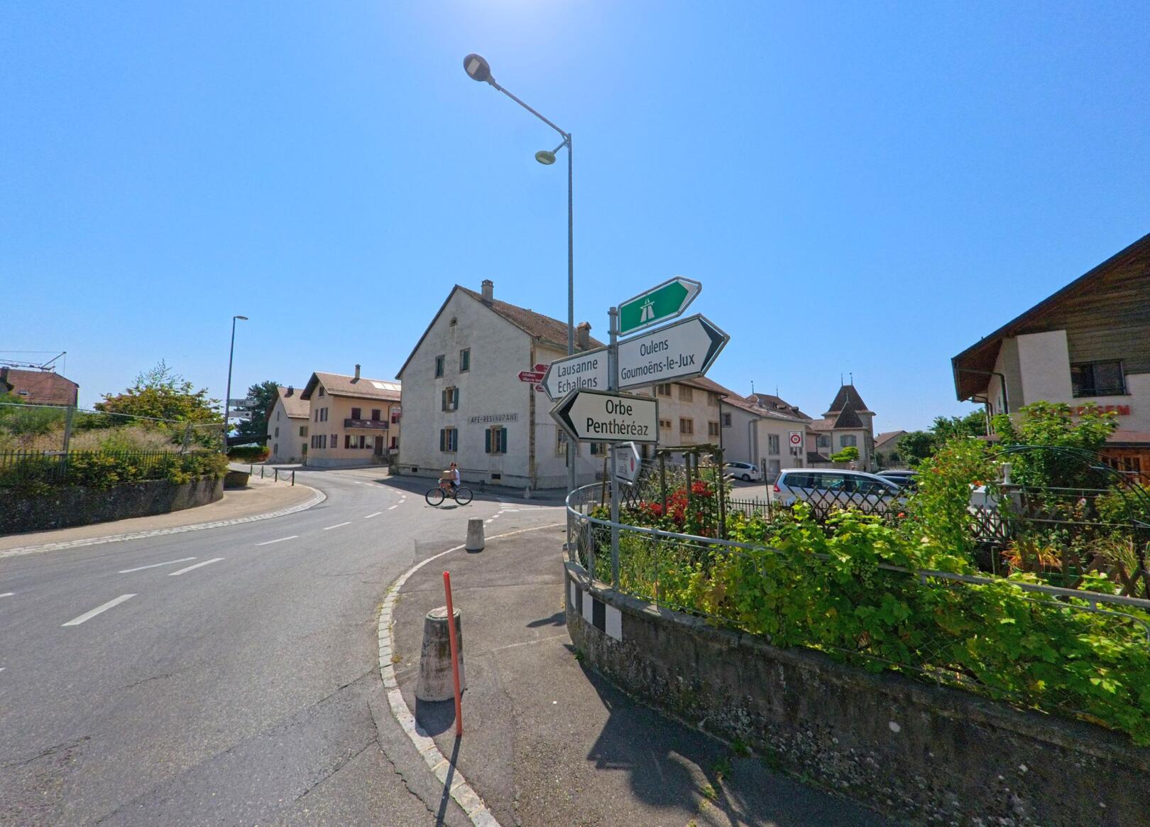 An einer Strassenkreuzung in Goumoens (1376, Kanton Waadt) weisen Wegweiser nach Lausanne, Orbe und weiteren Nachbargemeinden.