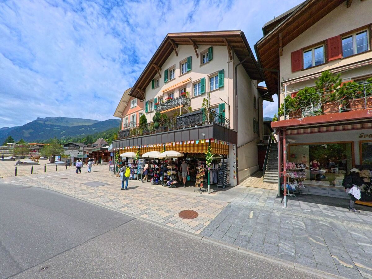 Im Zentrum von Grindelwald (3818, Kanton Bern) laden kleine Geschaefte mit Souvenirs und Kleidung in farbenfrohen Haeusern mit Markisen zum Einkaufen ein.