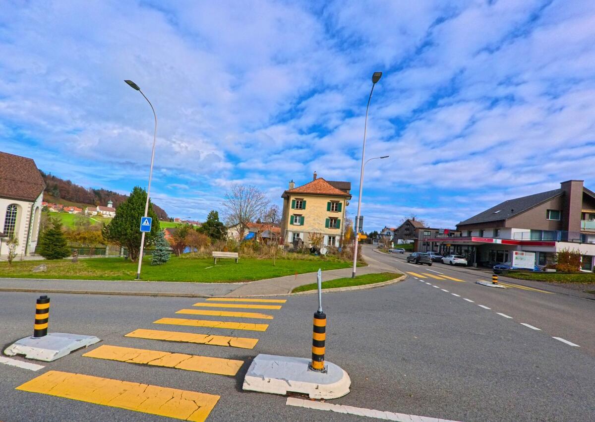 Ein Fussgängerstreifen mit Mittelinsel ordnet den Verkehr im Ortsgebiet von Grub (9035, Kanton Appenzell Ausserrhoden).