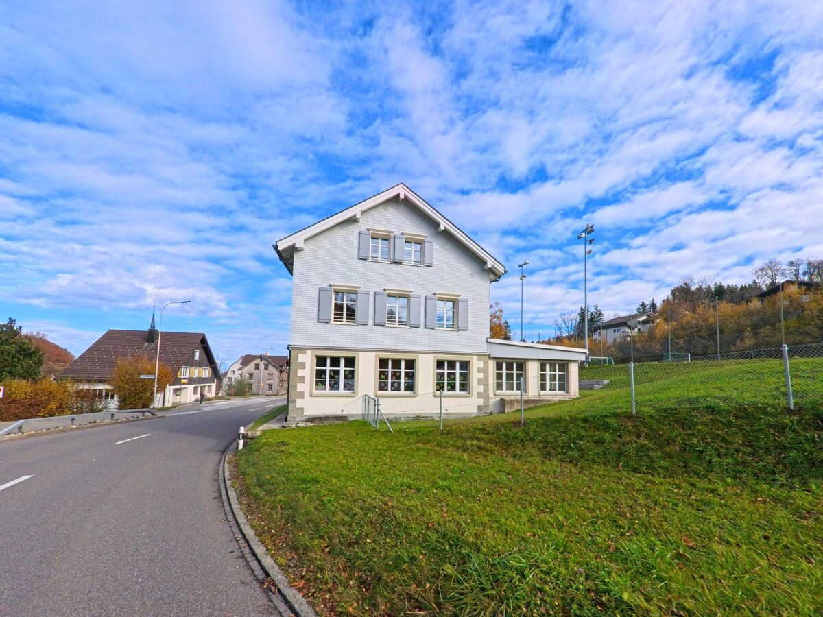 Ein helles Wohnhaus steht leicht erhöht am Rand der Strasse in Grub (9035, Kanton Appenzell Ausserrhoden).