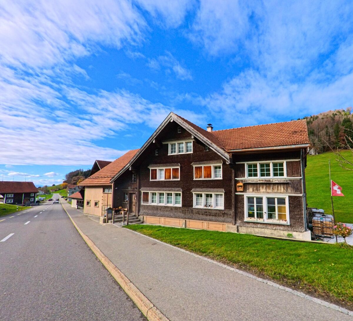 Ein traditionelles Holzhaus liegt direkt an der Dorfstrasse von Grub (9035, Kanton Appenzell Ausserrhoden).