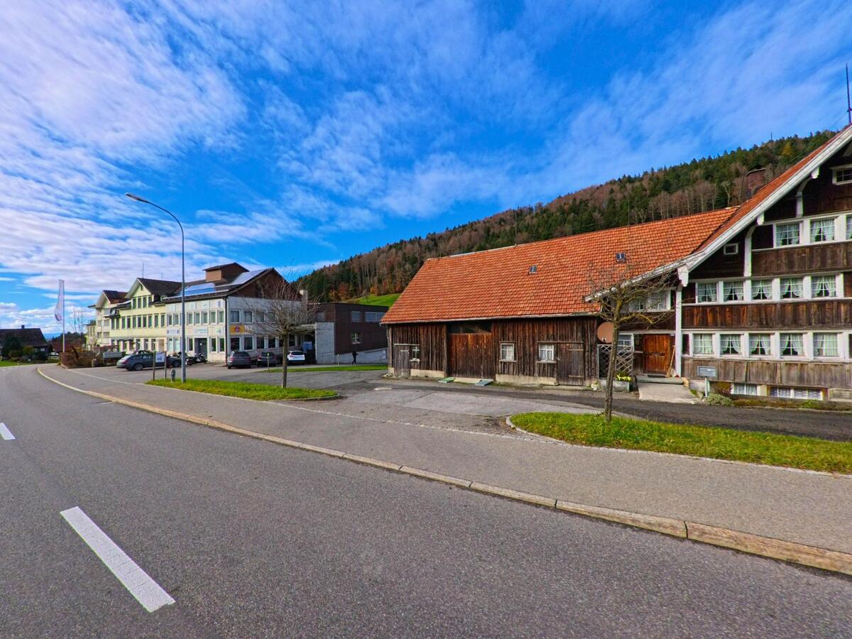 Ein Holzhaus mit angrenzendem Gewerbebau liegt an der Hauptstrasse von Grub (9035, Kanton Appenzell Ausserrhoden).