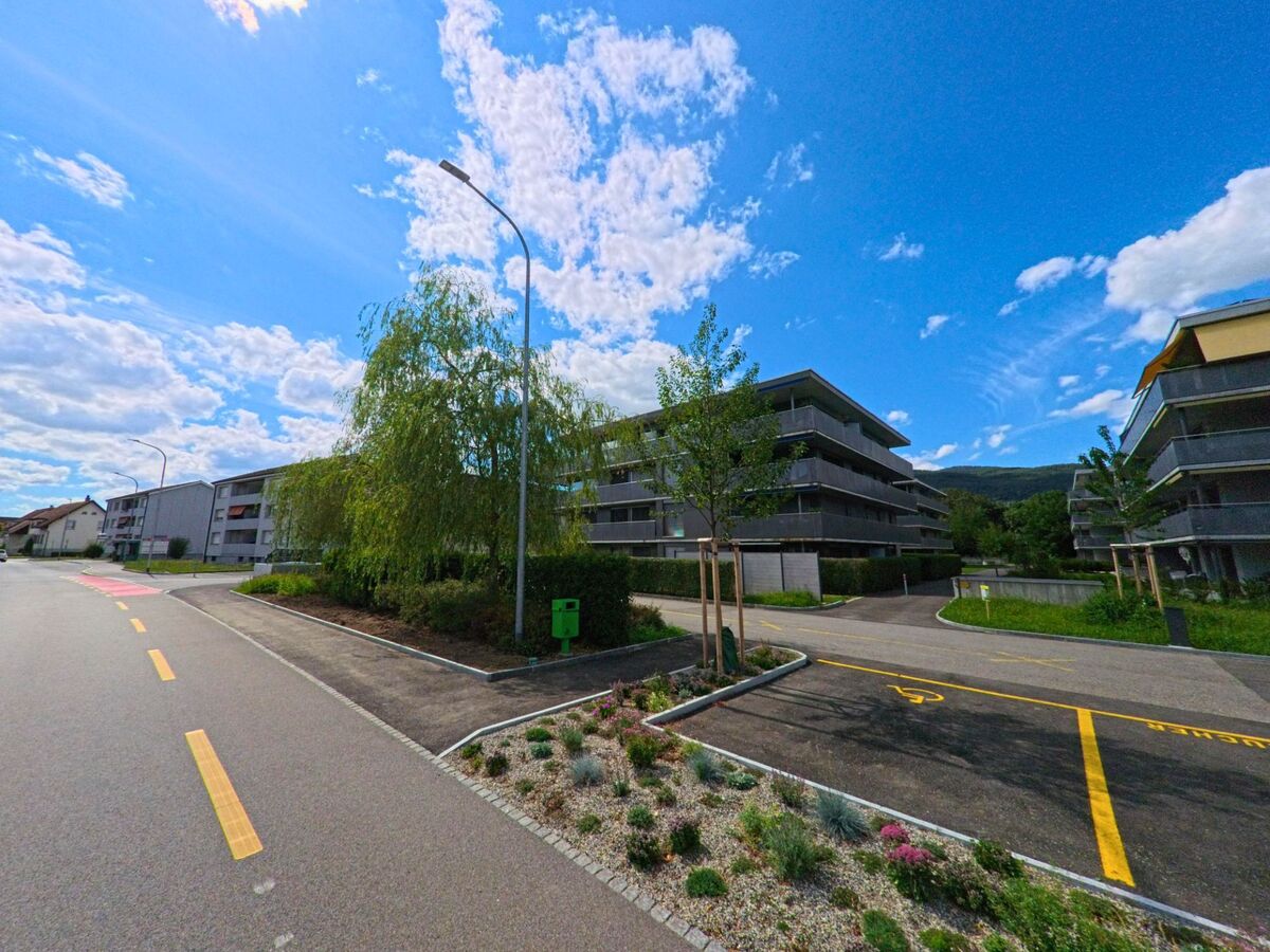 Moderne Mehrfamilienhaeuser mit Balkonen und gepflegten Gruenflaechen praegen das Wohnquartier in Gunzgen (4617, Kanton Solothurn) nahe einer ruhig verlaufenden Strasse.