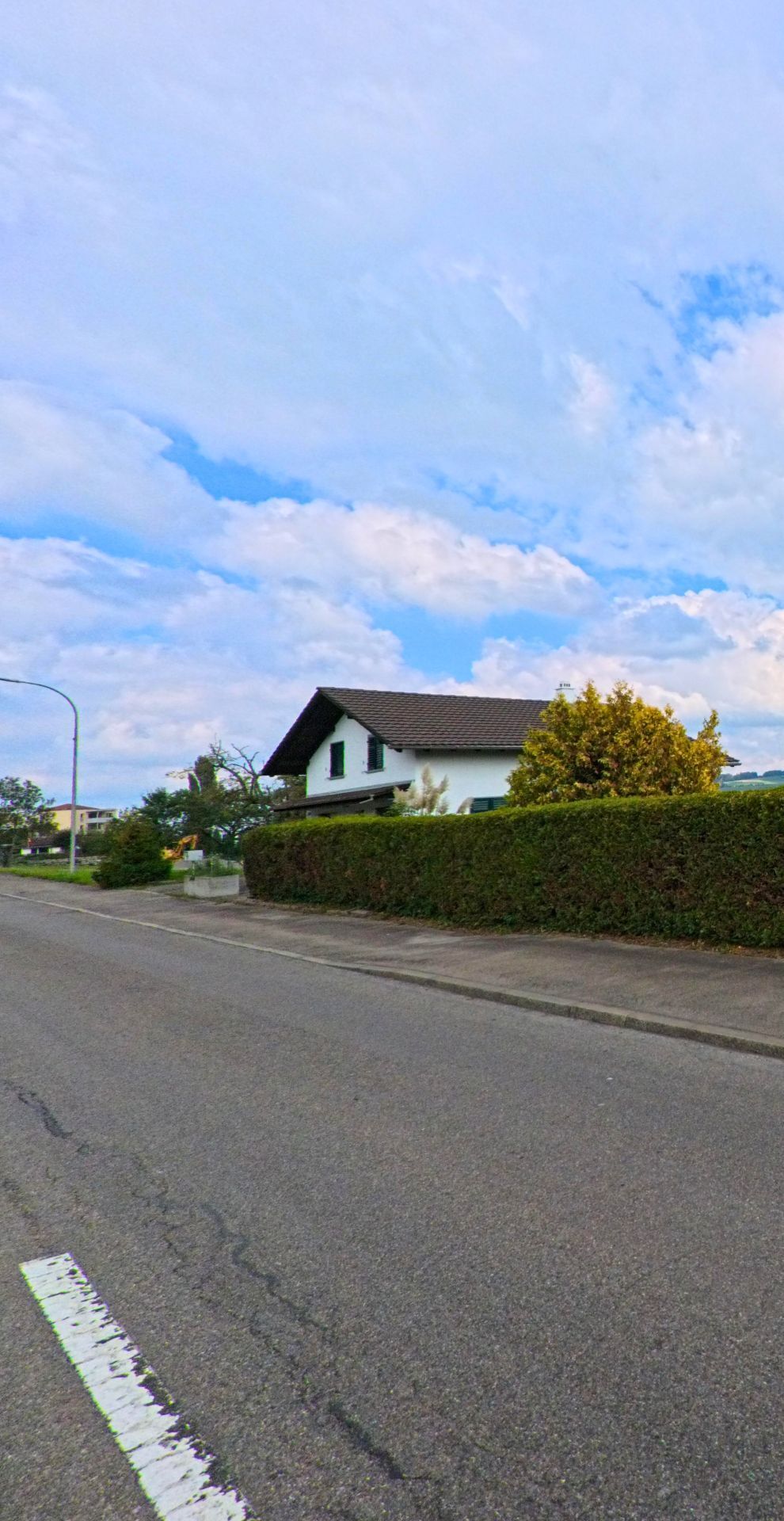 Ein Einfamilienhaus mit gruenen Fensterlaeden und gepflegter Hecke steht an einer ruhigen Strasse in Hallwil (5705, Kanton Aargau).