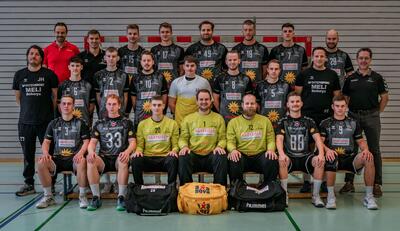 In einer Sporthalle in Muotathal (6436, Kanton Schwyz) sitzt und steht die erste Herrenmannschaft des Handball KTV Muotathal fuers offizielle Teamfoto in geschlossener Formation.