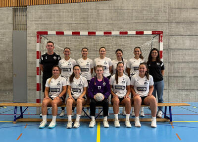 Die Spielerinnen des Handballclubs Büelen Nesslau posieren gemeinsam mit ihrem Trainerteam vor einem Handballtor in Nesslau (9650, Kanton St. Gallen).