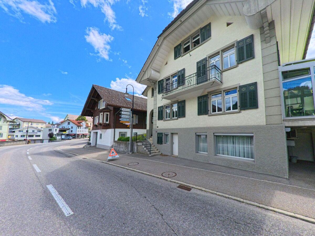  Eine kurvige Strasse in Hasle (6166, Kanton Luzern) führt an dicht beieinander stehenden Wohnhäusern vorbei, teils mit traditionellen Fensterläden.